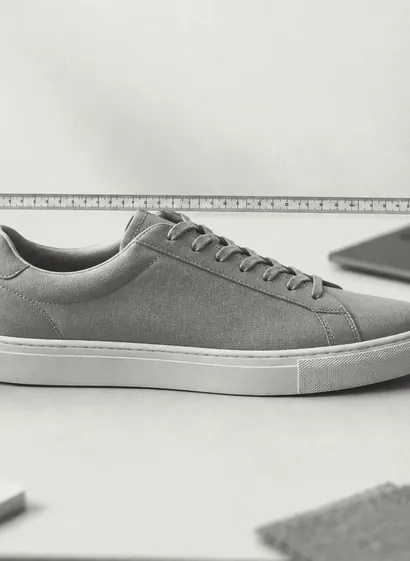 Ein Sneaker wird mit dem Maßband vermessen